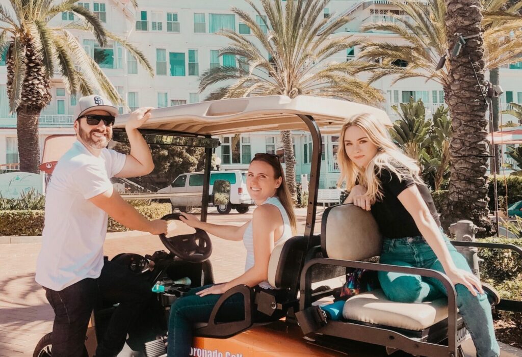 Three happy people on a golf cart at the Hotel Del Coronado